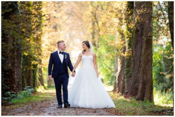 Hochzeitspaar spaziert durch eine Allee hinter dem Rittergut in Großgoltern.